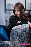 ブラックのローカットトップスとブルーのロングスカートを纏って正面に立つ美人ラブドール
